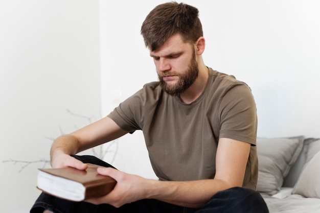 Мужчина среднего роста держит библию