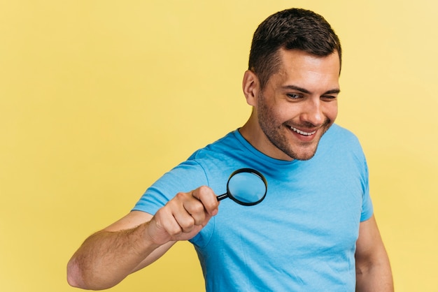 Free photo medium shot man holding a magnifier