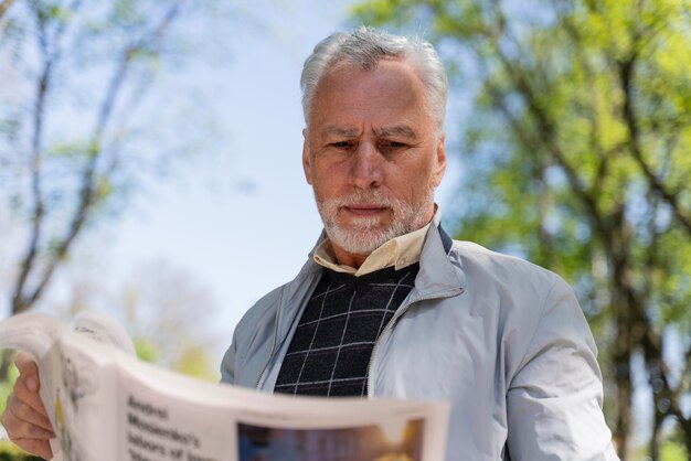 新聞を持っているミディアムショットの男