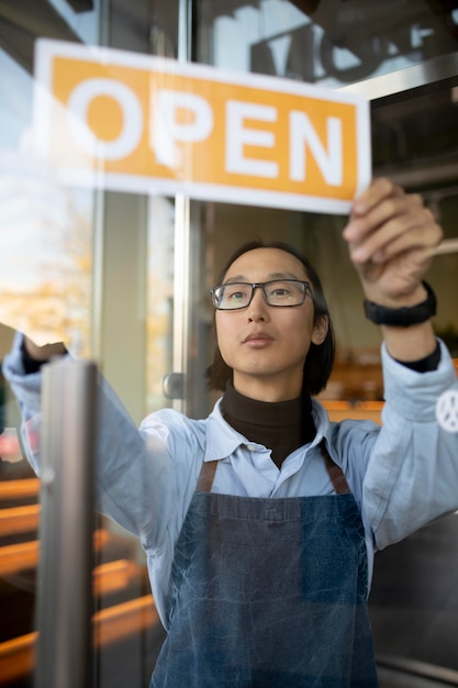 Medium shot man holding open sign
