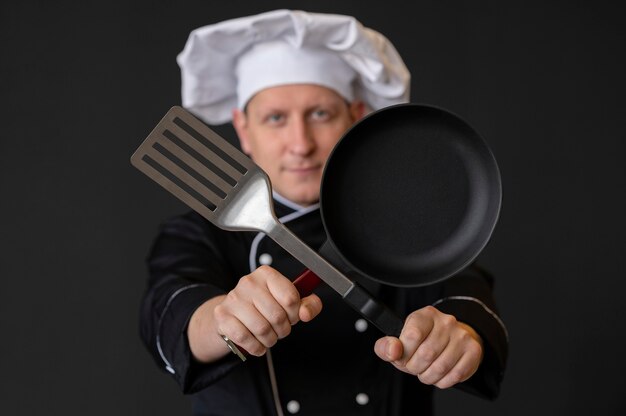 Medium shot man holding pan and spatula