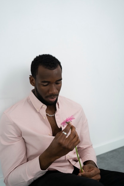 Free photo medium shot man holding pink flower