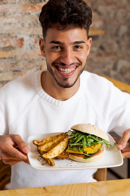 Foto gratuita piatto della holding dell'uomo del colpo medio con il cibo