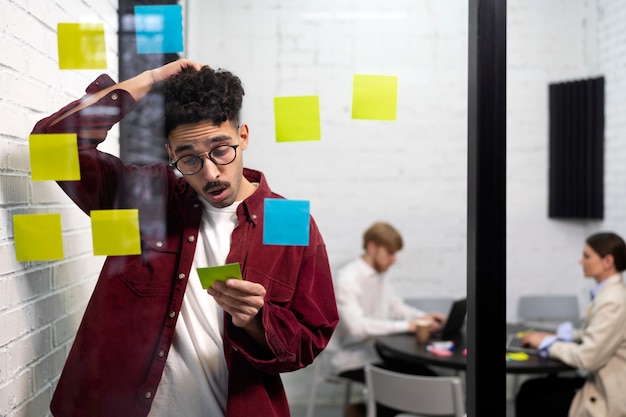 Medium shot man holding post it