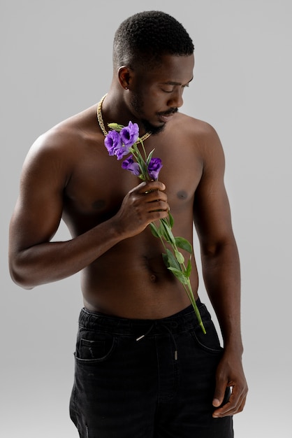 Free photo medium shot man holding purple flower