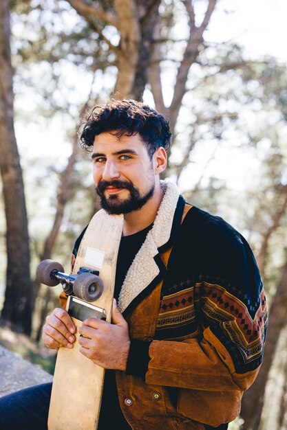 Medium shot of man holding skateboard