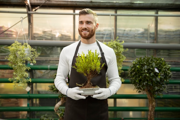 Medium shot man holding small tree