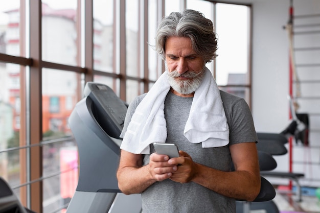 スマートフォンを保持しているミディアムショットの男