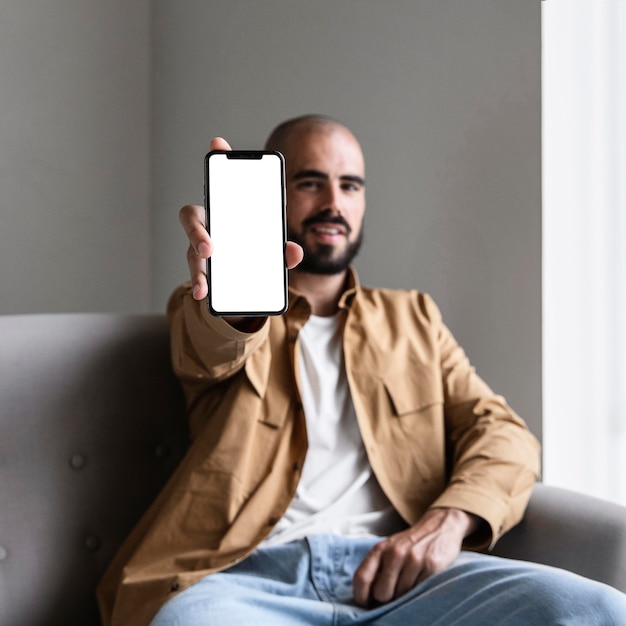 Средний выстрел мужчина держит смартфон