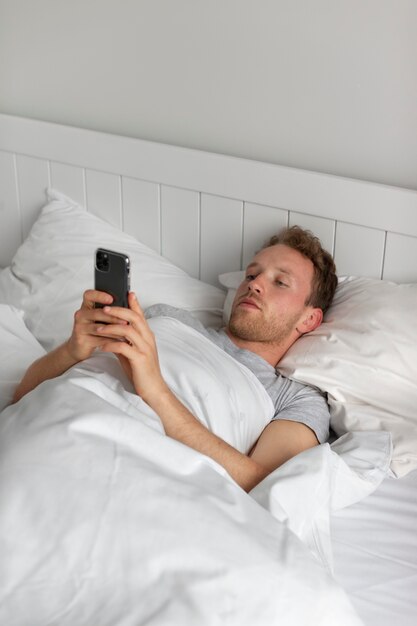 スマートフォンを持っているミディアムショットの男