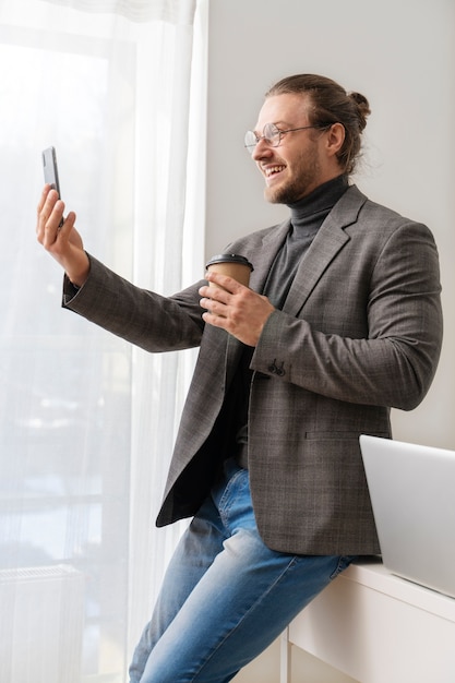 スマートフォンを持っているミディアムショットの男