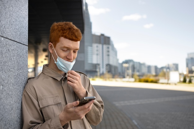 Free photo medium shot man holding smartphone