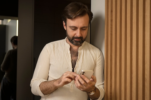 Medium shot man holding smartphone