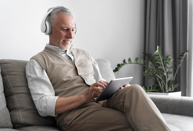 Medium shot man holding tablet inside