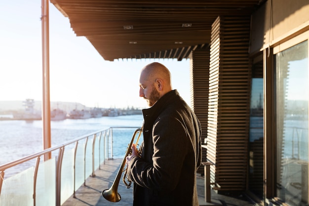 Free photo medium shot man holding trumpet