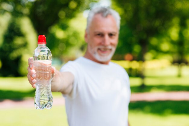 水のボトルを保持しているミディアムショット男