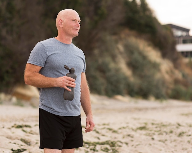 Free photo medium shot man holding water bottle