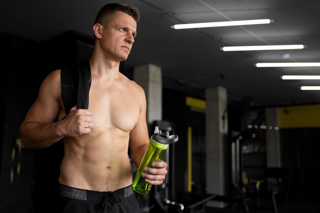 Medium shot man holding water bottle