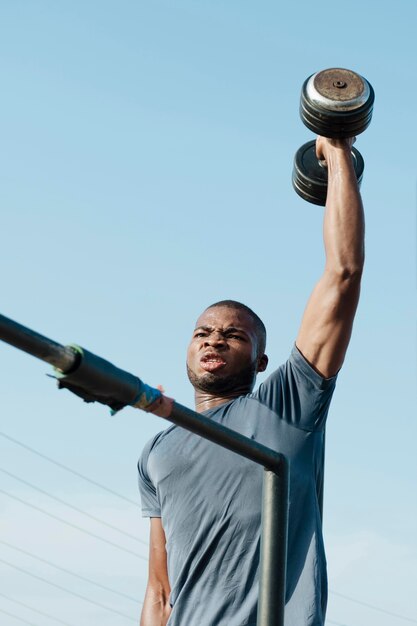 Medium shot man holding weight up