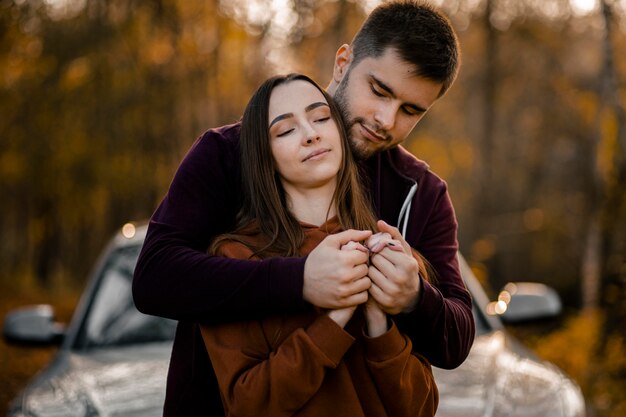 Medium shot man holding woman in forest