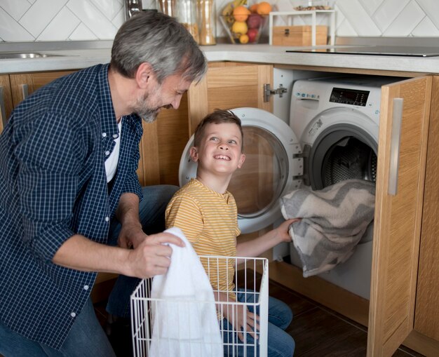 ミディアムショットの男と子供が洗濯をしている