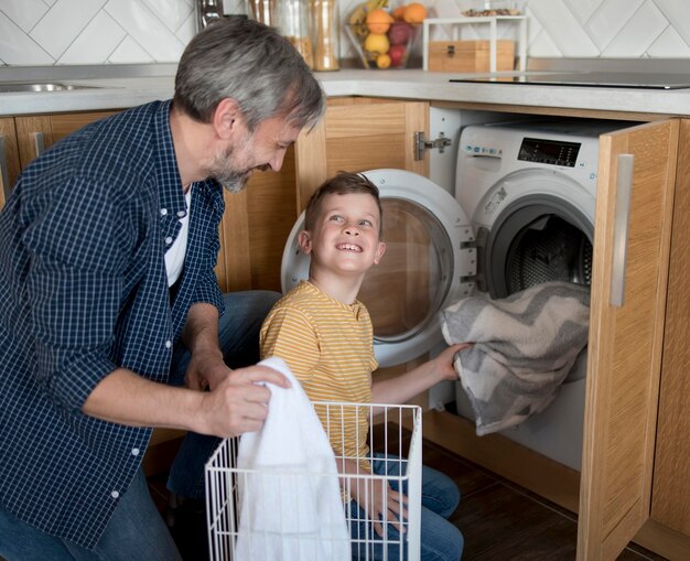 Medium shot man and kid doing laundry