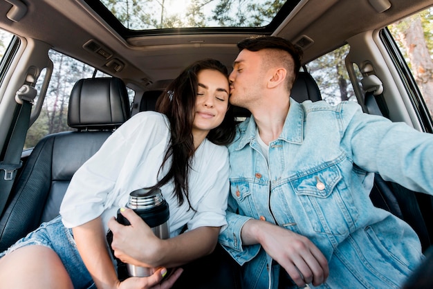 Uomo del colpo medio che bacia la ragazza