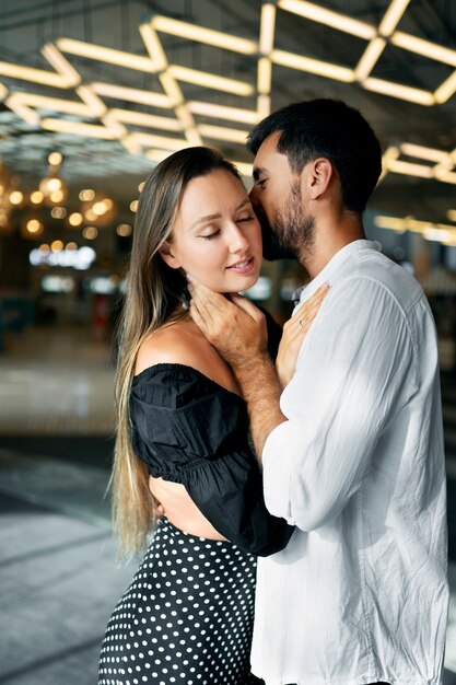 Uomo del colpo medio che bacia la donna sulla guancia