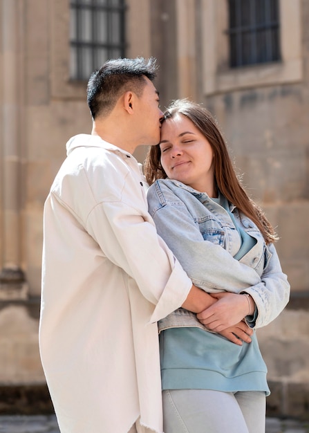 Free photo medium shot man kissing woman on forehead