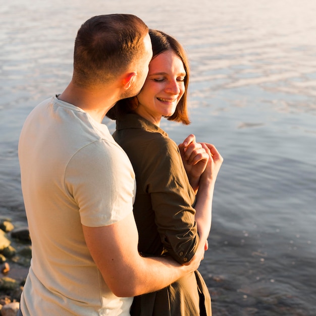 Medium shot man kissing woman on head