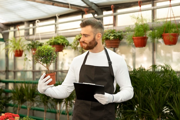 Medium shot man looking at plant