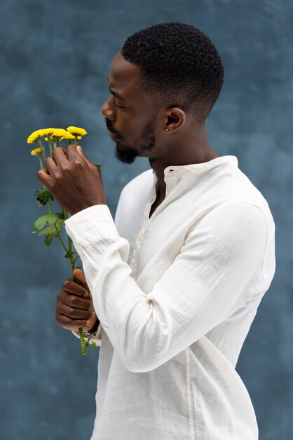 Uomo del tiro medio che guarda i fiori gialli