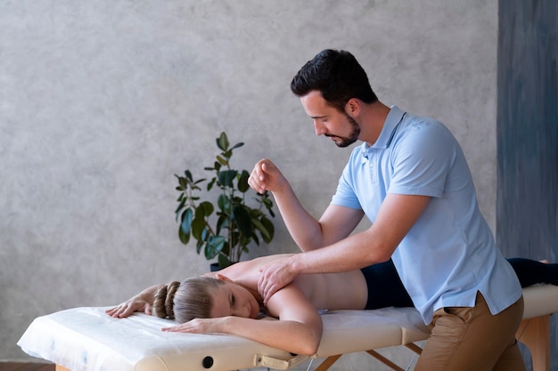Foto gratuita uomo a colpo medio che massaggia il paziente