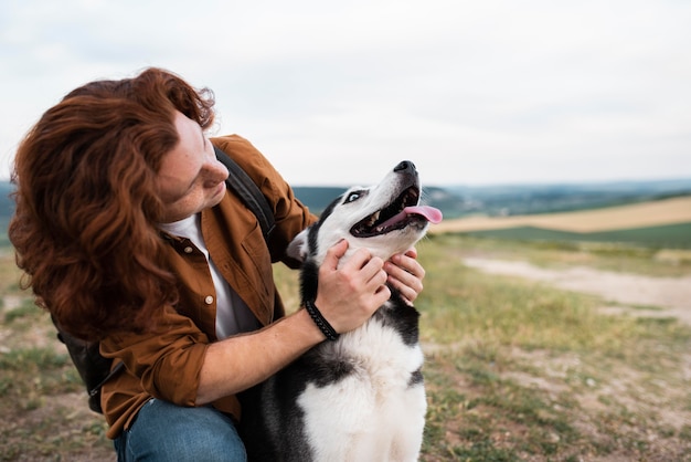 ミディアムショットの男が犬をかわいがる