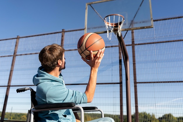 Бесплатное фото Средний выстрел мужчина играет в баскетбол