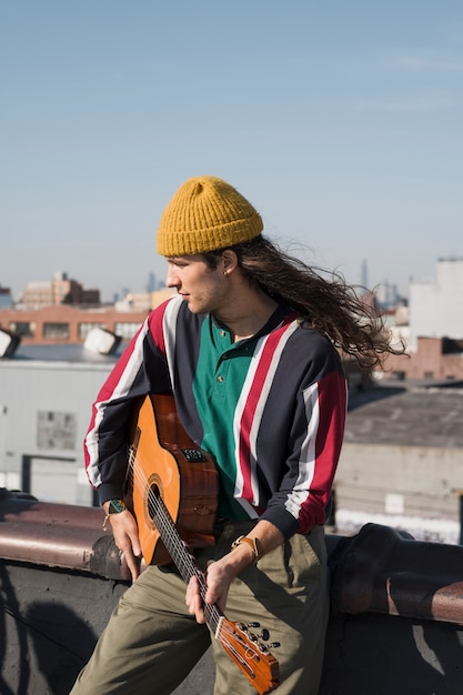 Foto gratuita uomo di tiro medio che suona la chitarra