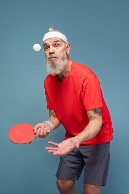 Мужчина среднего роста играет в пинг-понг