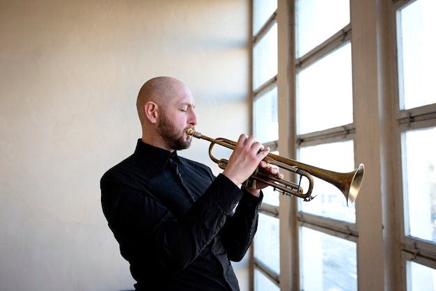 Medium shot man playing the trumpet