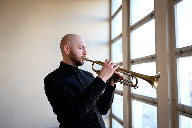 Medium shot man playing the trumpet