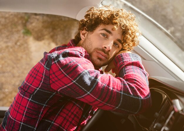 Medium shot man posing in car