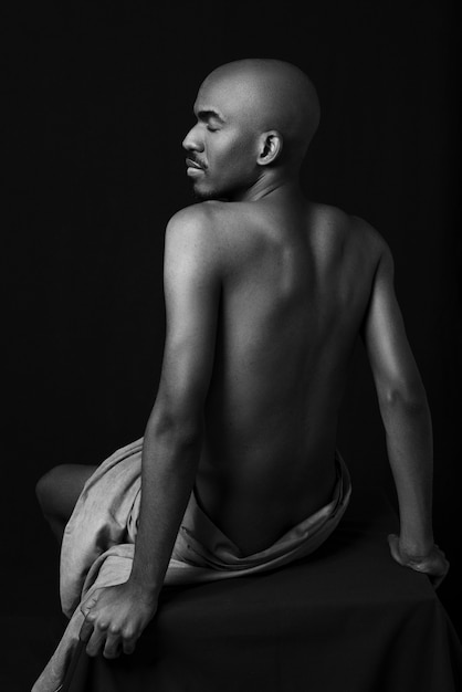 Medium shot man posing on chair black and white