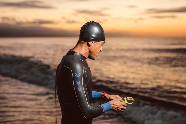 Foto gratuita uomo del colpo medio che posa in riva al mare