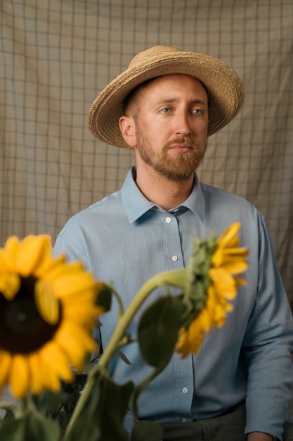 Medium shot man posing with sunflowers