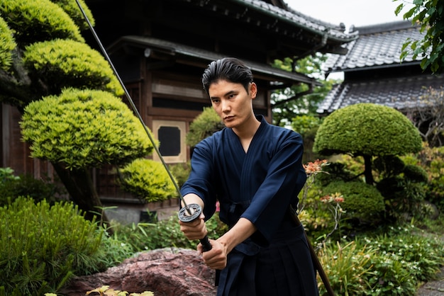 Мужчина среднего роста тренируется с самурайским мечом
