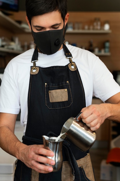 Uomo del colpo medio che prepara caffè