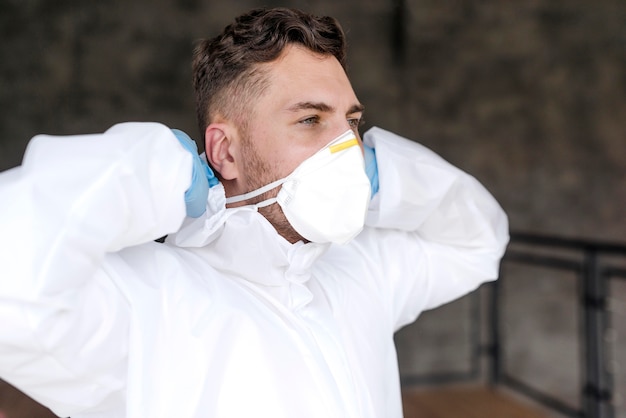 Free photo medium shot man putting on mask