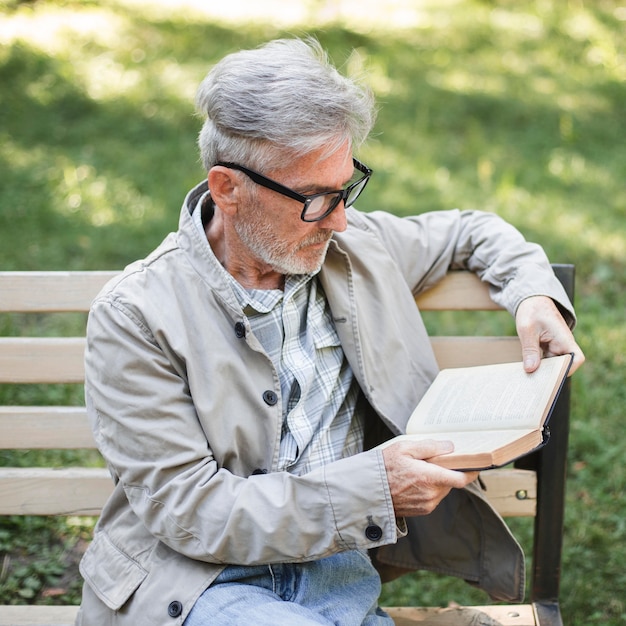 Medium shot man reading on bench