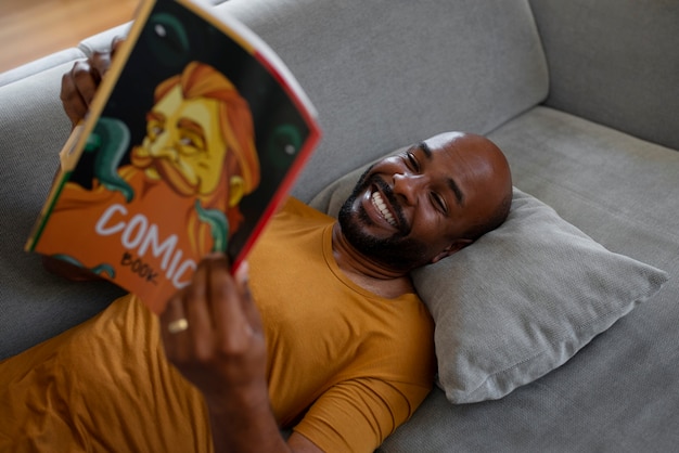 家で漫画を読むミディアムショットの男性