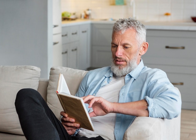 ソファで読書ミディアムショットの男