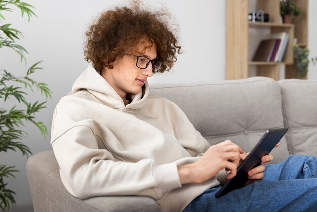 Free photo medium shot man reading digital magazine